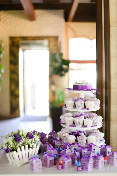 Decoraciones violetas y dulces pasteles deliciosos para la fiesta . — Foto de Stock