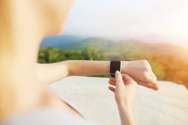 Gün ışığı ile arka plan dağlarda smartwatch kullanarak eller fotoğrafı.