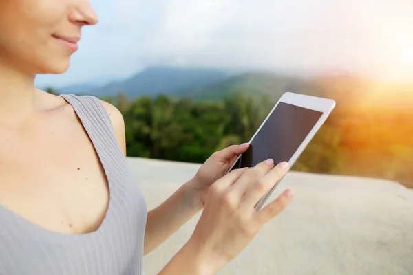 Suny foto retrato de una joven rubia usando smartwatch, montañas en el fondo, Bali . — Foto de Stock