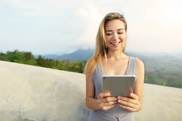 Young blonde woman using tablet with mountains background, Thailand. — Stock Photo, Image