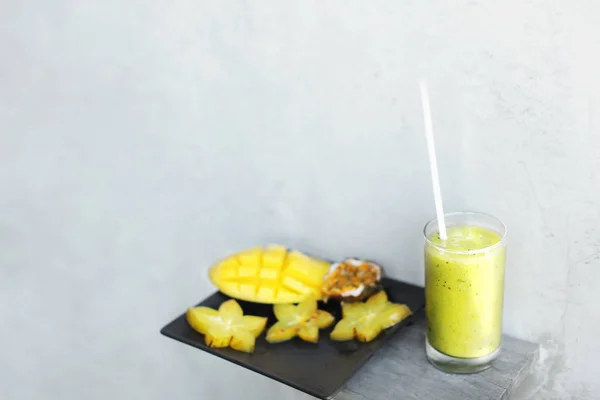 Grüner frischer Saft und Mango mit Karambola auf Teller, weißer Hintergrund mit Copyspace. — Stockfoto