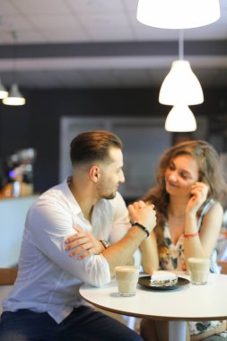 Genç kız ve lezzetli kek yakınındaki kafede oturan ve elele çocuk.