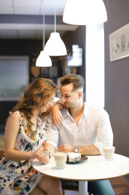 Genç beyaz kız ve erkek kafede oturan, kahve içme ve dinlenme.