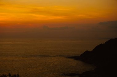 Şaşırtıcı turuncu gökyüzü, sakin günbatımı hava ve deniz.