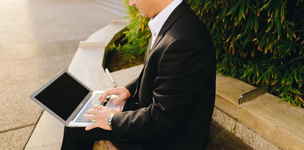 Empresário trabalhando com laptop fora perto da planta em   . — Fotografia de Stock