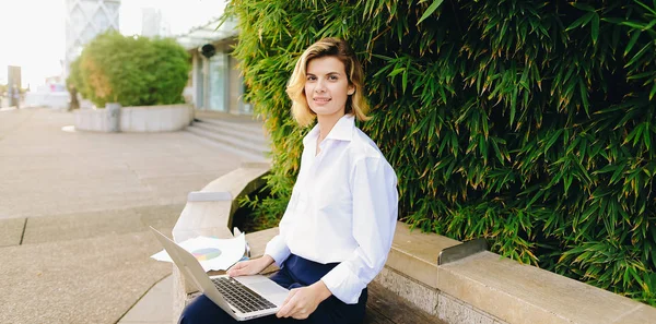 Caucásica mujer de negocios que trabaja con el ordenador portátil y papeles en abierto un — Foto de Stock