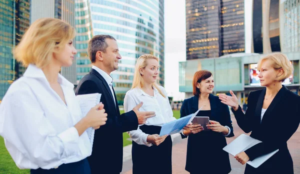 Employees of large corporation going with document case, laptop