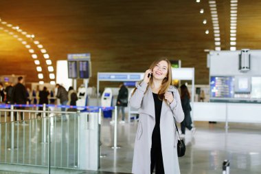 Genç kadın smartphone vasıl havaalanı bekleme salonu, kopya alanı tarafından söz.