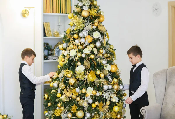 Dos niños pequeños decorando abeto para las vacaciones de Navidad . — Foto de Stock