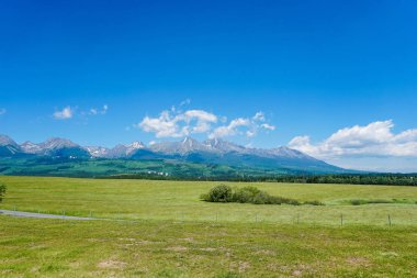 Mavi gökyüzü arka plan ve çim alanı ile Slovakya'da harika Tatra Dağları.