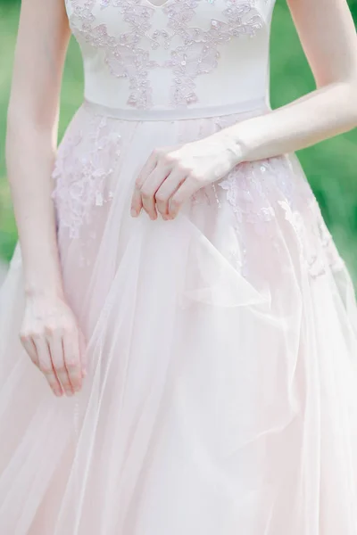 Zbliżenie światło różowa sukienka i ślubny kobiece dłonie. — Zdjęcie stockowe