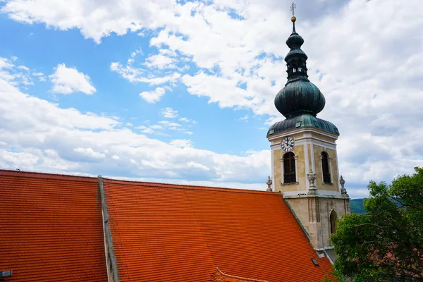 Austrian Christian church with red tiled roof. Stock Photo