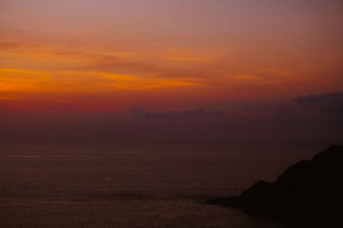 Sakin deniz günbatımı arka planda.