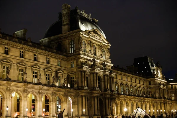 Noche increíble Louvre y turistas caminando en París, Francia . — Foto de Stock