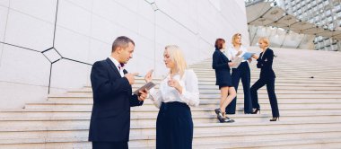 Sekreter patron tutma tablet ile istihdam ile merdivenlerde konuşurken