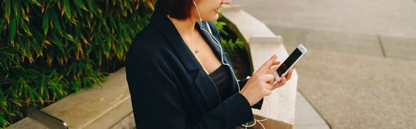 Secretaria escuchando música con auriculares y smartphone o — Foto de Stock