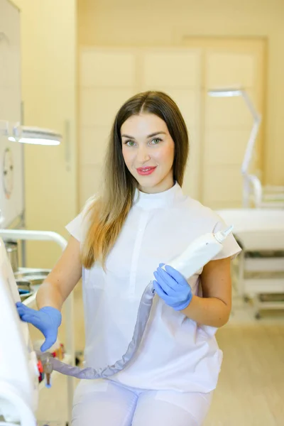 Permanenter Visagist sitzt mit Laserentfernungsgerät im Schönheitssalon. — Stockfoto