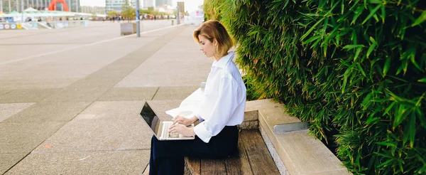 Nahaufnahme des Gesichts einer Frau, die mit Laptop im Freien tippt. — Stockfoto