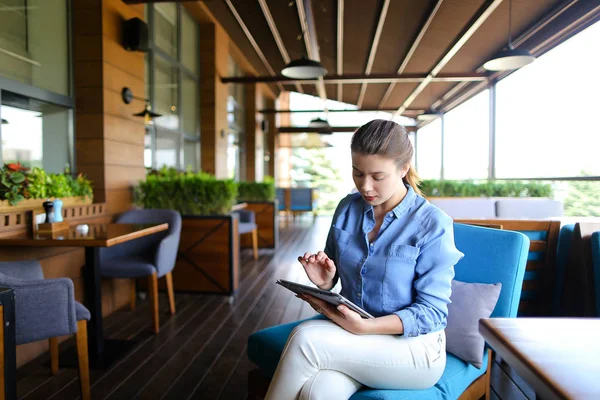 Hermosa chica trabajando con la tableta en el restaurante   . — Foto de Stock