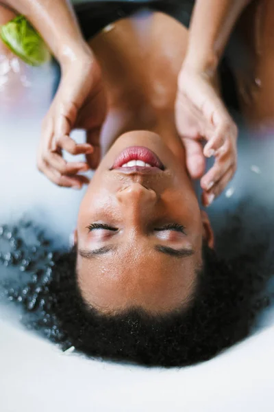 Afro amerikansk flicka tar bad och ligga i skum, bär baddräkt. — Stockfoto