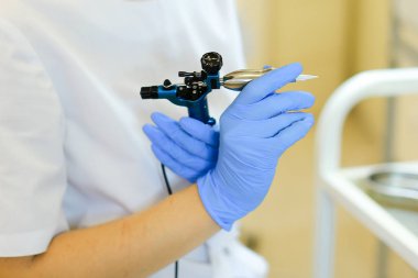 Güzellik uzmanı eller microblading aygıt güzellik salonunda tutmak yukarıya kapatmak.