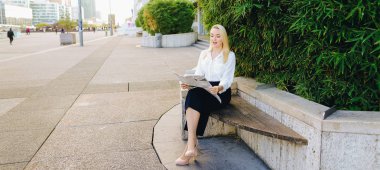 Açık havada yüz yakından ile gazete okuyan Bayan.