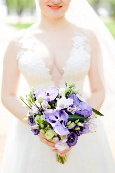 Aucasian happy bride keeping bouquet of flowers and wearing white dress with veil. — Stok Foto