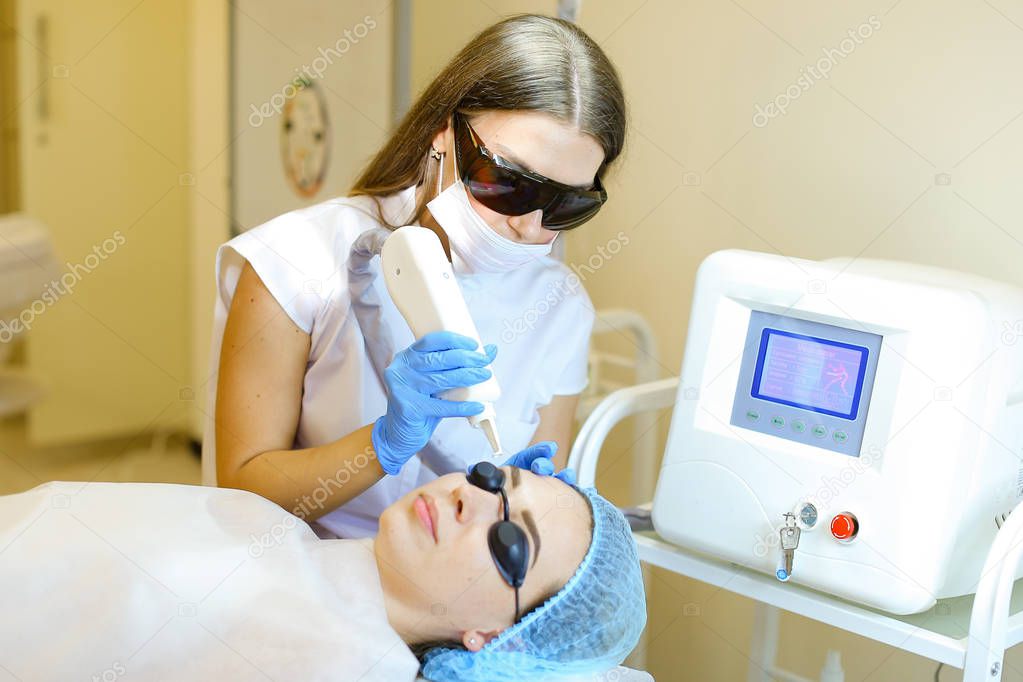Young cosmetologist removing permanent makeup with laser for young girl.
