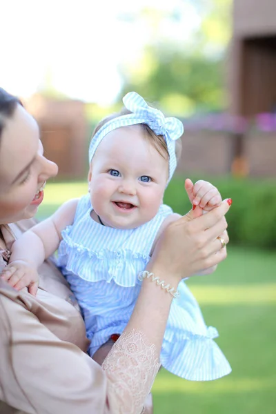 Primo piano madre felice che tiene piccolo bambino femmina in abito blu . — Foto Stock