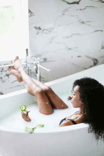 Young black girl lying in bathroom with marble tile and relaxing. — Stock Photo, Image