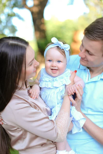 Jóvenes padres felices sosteniendo hija pequeña . — Foto de Stock