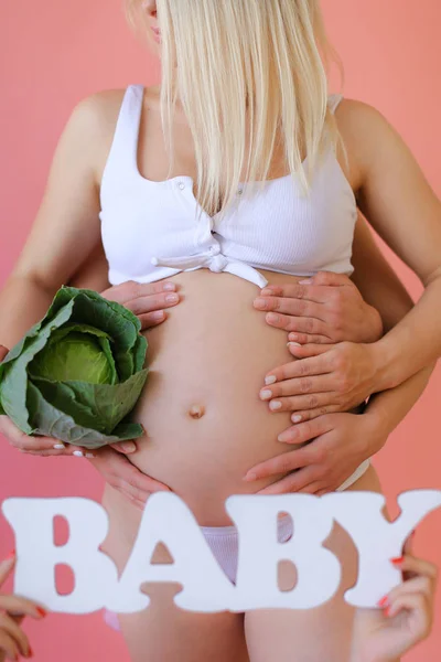 Primo piano donna incinta in biancheria intima mantenere iscrizione bambino e cavolo . — Foto Stock