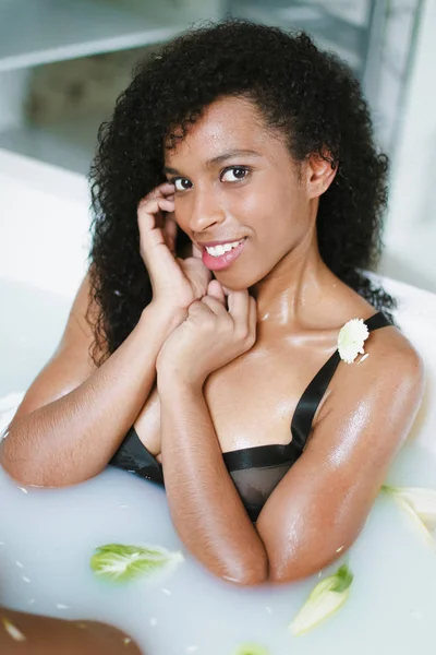 Jeune belle afro américaine fille prenant bain avec de la mousse et portant un maillot de bain noir . — Photo