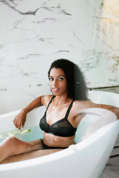 Young afro american girl taking bath and wearing black swimsuit. — Stock Photo, Image