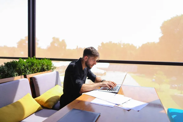 Quantity surveyor werken aan café tafel met papieren en laptop. — Stockfoto