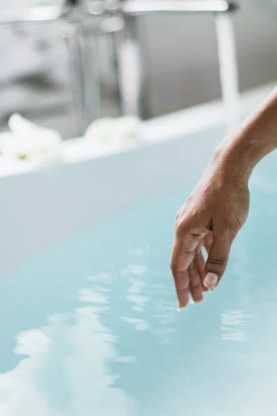 Geïsoleerde Afro Amerikaanse hand met kopieerruimte in blauw water achtergrond. — Stockfoto