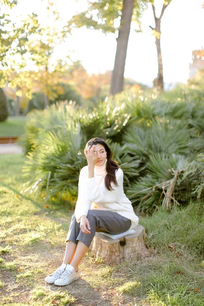 中国女孩坐在公园的树桩. — 图库照片