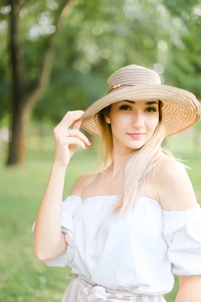 Retrato de una joven rubia guapa usando sombrero y sonriendo . — Foto de Stock