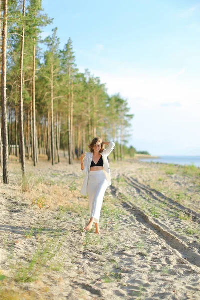 Frau läuft am Sandstrand und trägt weiße Kleidung. — Stockfoto