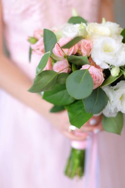 Açık pembe elbise arka planda çiçek buketi kadar yakın.