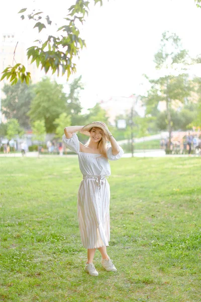 Jeune fille caucasienne portant chapeau et robe, debout dans le parc . — Photo