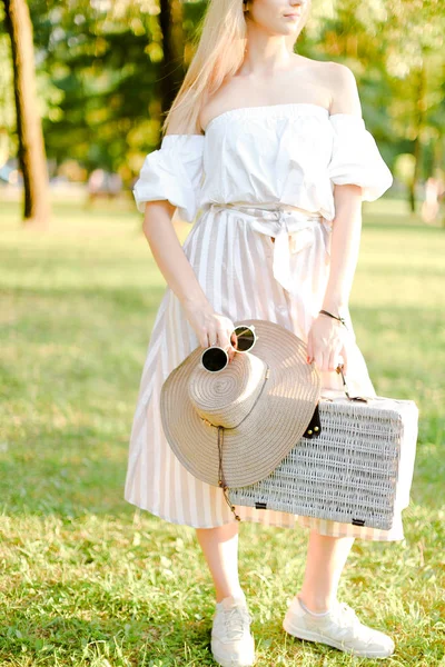 Kaukasisk kvinnlig person stående med solglasögon och väska i parken. — Stockfoto