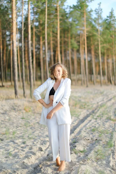 Blonde Europäerin läuft am Sandstrand und trägt weiße Kleidung. — Stockfoto