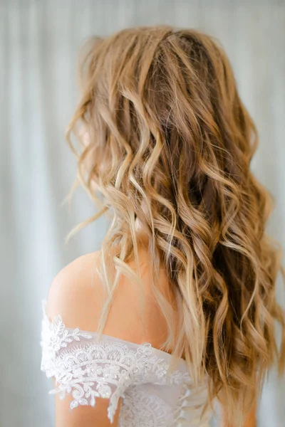 Pohled na nevěstu s dlouhými kudrnatými vlasy ve fotostudiu. — Stock fotografie