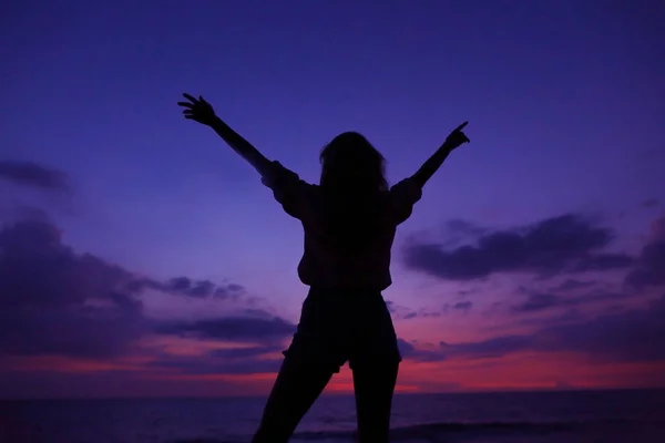 Silueta femenina negra en el cielo violeta al atardecer con nubes en el fondo, Hawaii . — Foto de Stock