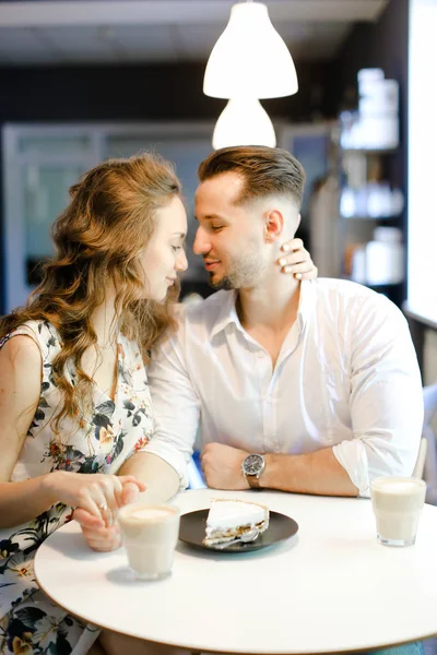 若いかわいい女の子と男の子がカフェに座って、コーヒーを飲んで、休んでいる. — ストック写真