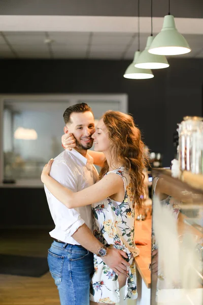 Junge süße Frau umarmt Ehemann im Café. — Stockfoto