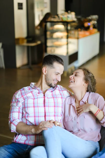 Junges fröhliches Mädchen sitzt mit Freund drinnen und redet. — Stockfoto