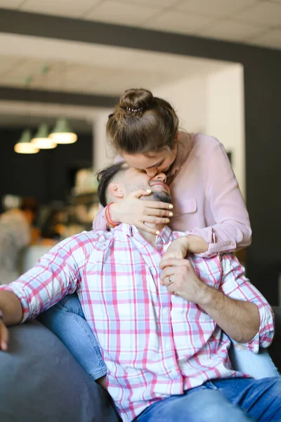 Young caucasian wife kissing husband at home. — Stock Photo, Image