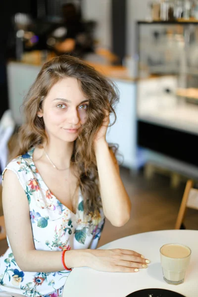 Mujer joven con taza de café sentada en la cafetería y descansando . —  Fotos de Stock